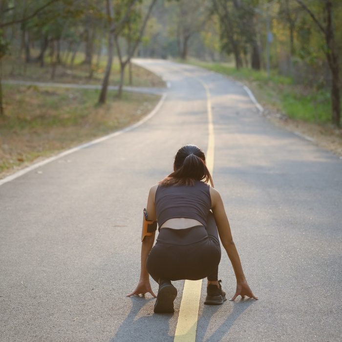 Young asian woman preparing for start morning jogging session in the park.